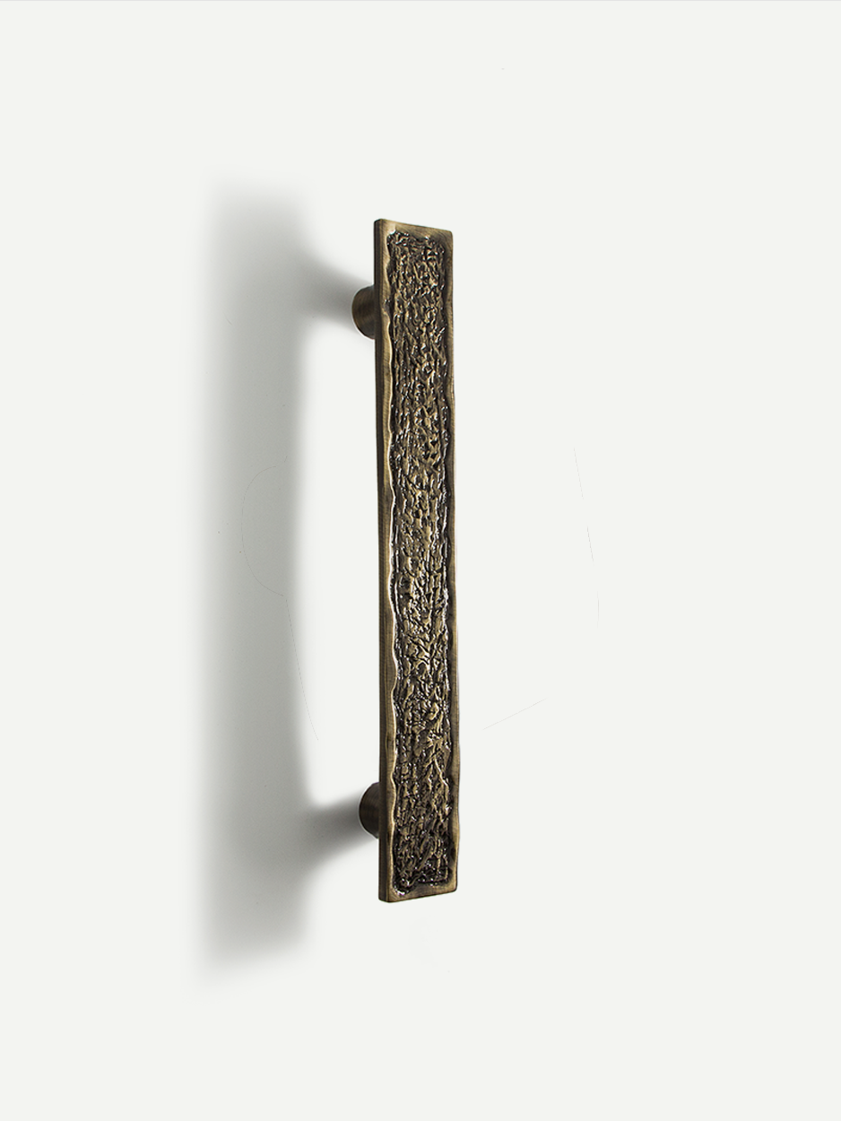 Tall brass entry door pull handle with texture finish.