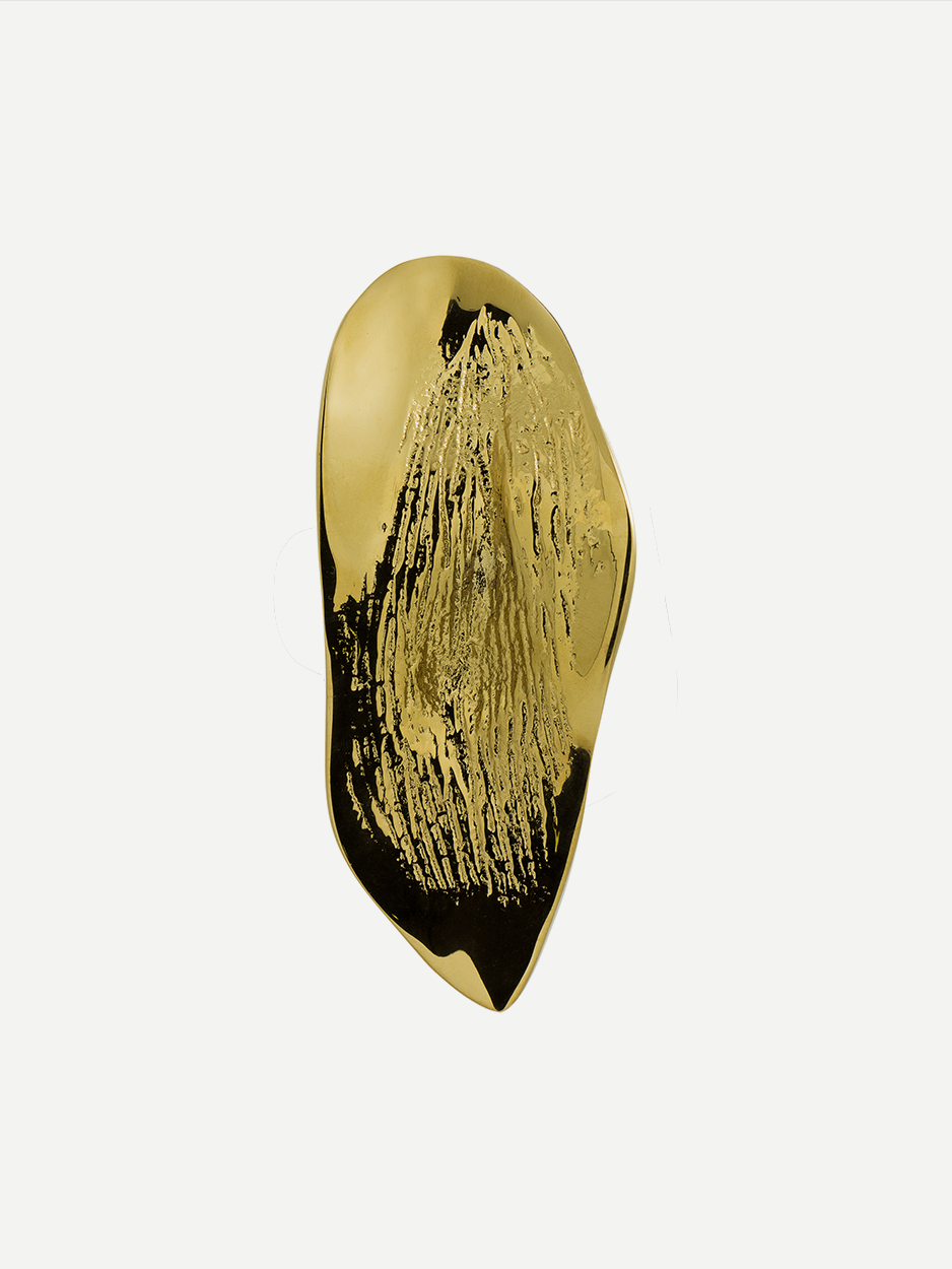 Textured cabinet and drawer pull in a Gold PVD finish, shaped like a leaf and inspired by natural lava flows.