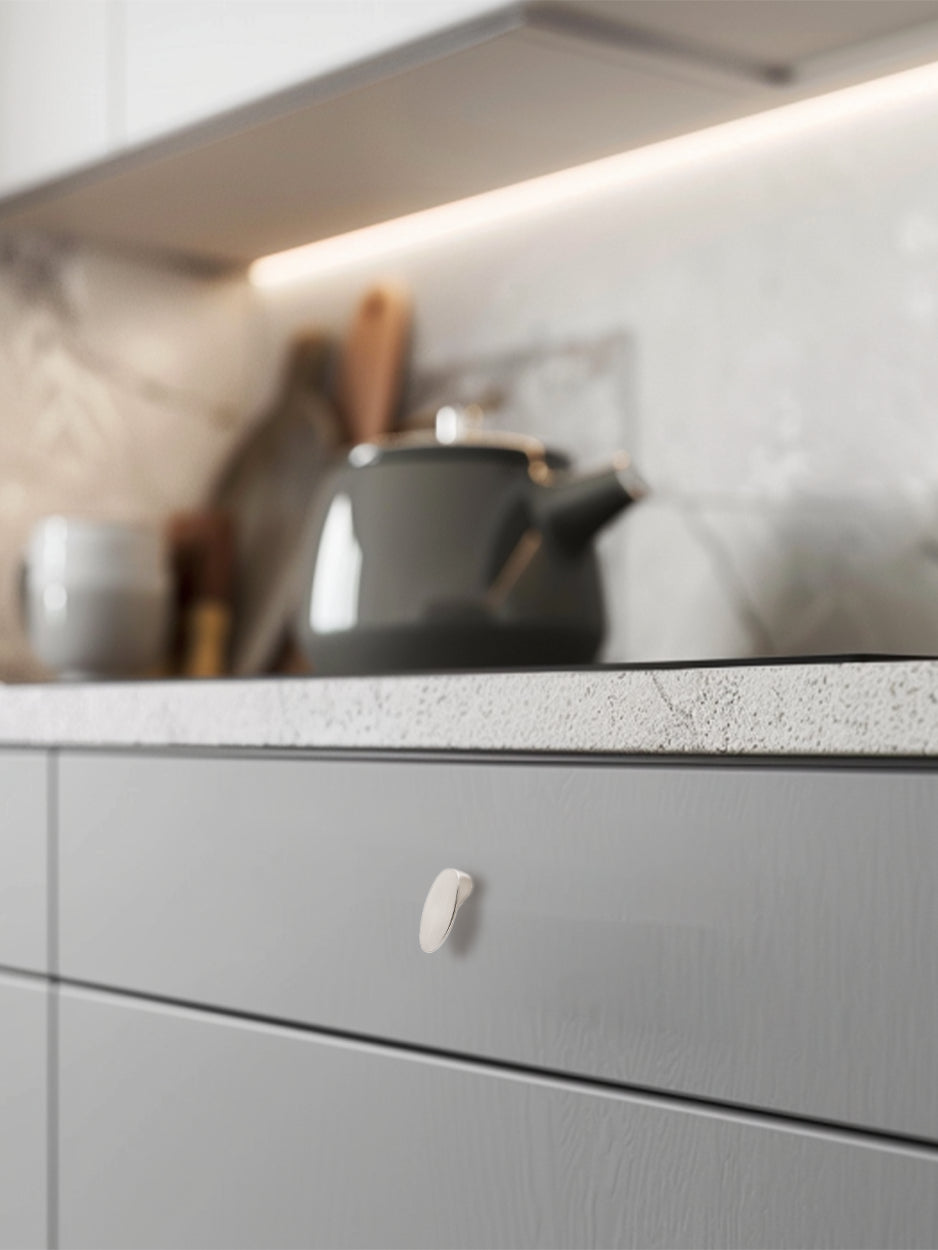 Mockup image of the Ellipsis knob installed on furniture, demonstrating its stylish impact in a real-world setting. Keywords: luxury drawer knob mockup, furniture hardware, modern interior design, kitchen drawer knob.