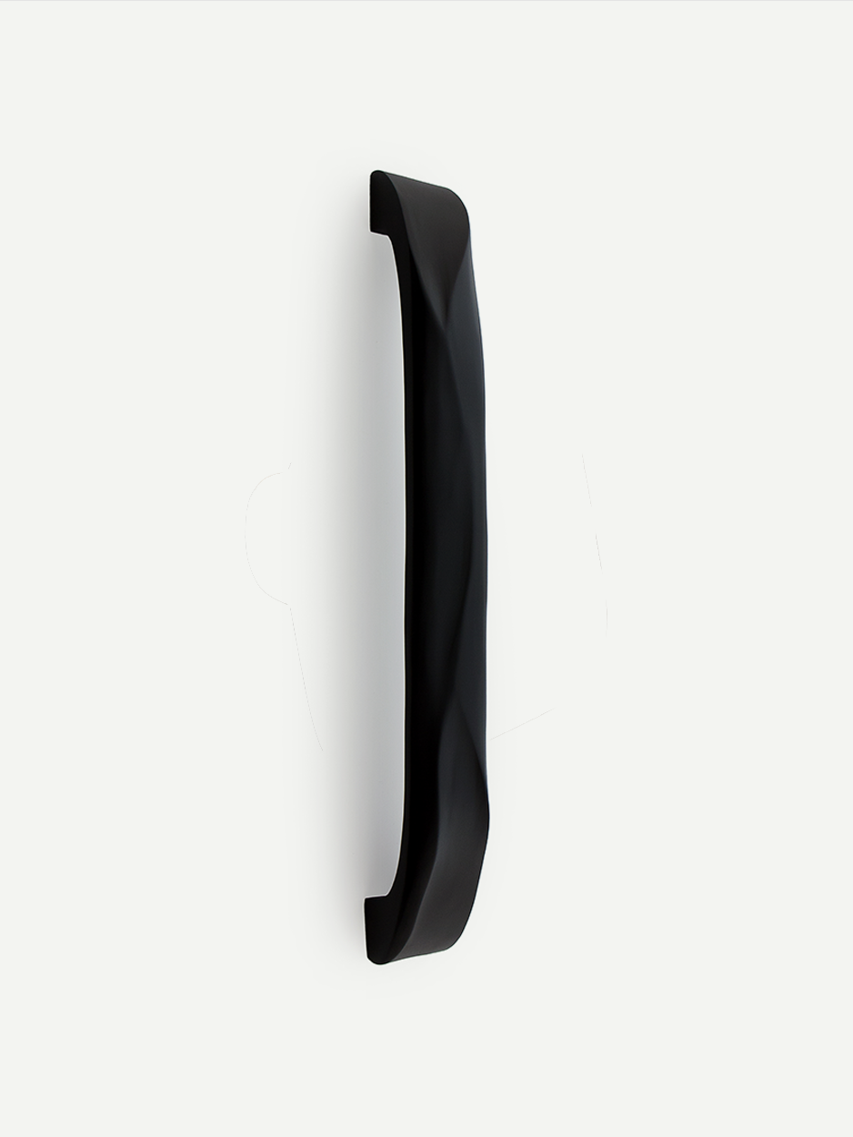 CHISEL front door handle in black matte finish, featuring its chiselled, minimalist design. The handle's sleek surface and subtle sheen add a touch of modern luxury to the entryway.