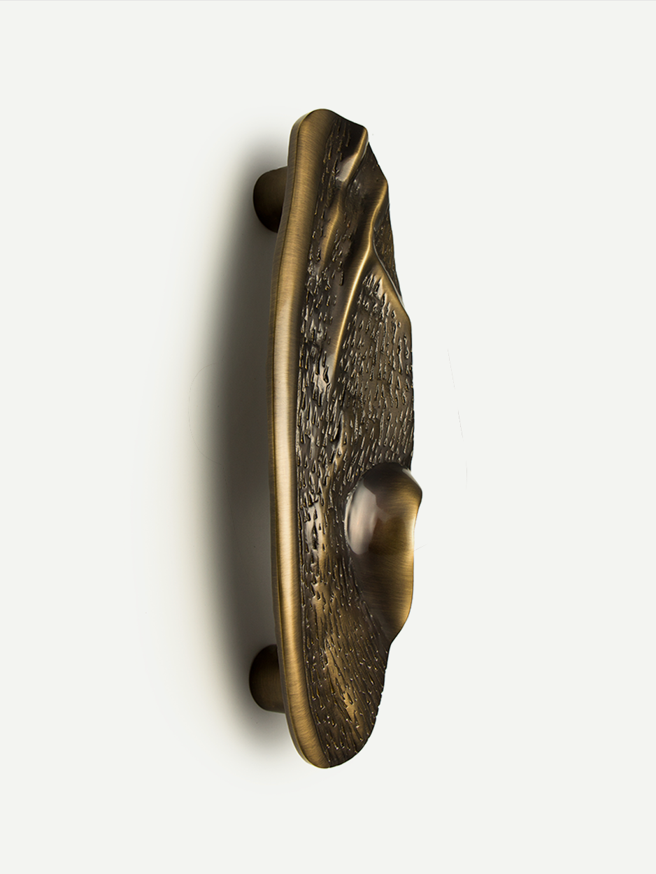 Front view of the FLUID sculpted front door pull in a glossy bronze finish, showcasing its free-flowing, abstract design and textured facets, perfect for adding luxury to any home entrance.