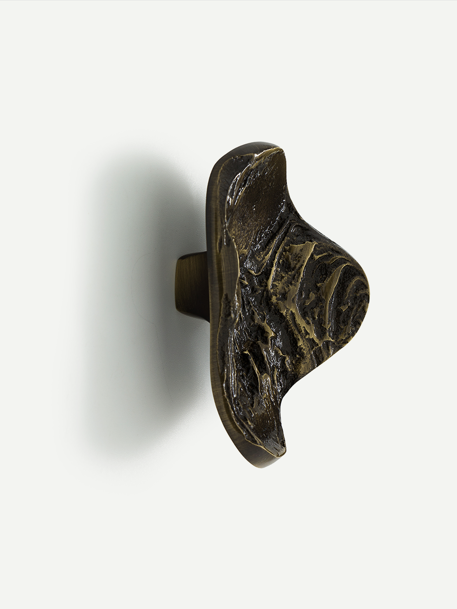 LAVA 2 cabinet and drawer pull in glossy bronze, featuring a unique texture inspired by hardened lava. This luxuriously handcrafted pull adds an elegant and distinctive accent to your cabinetry.