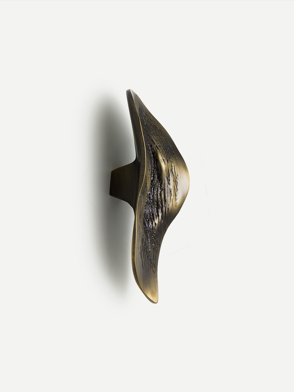 Textured cabinet and drawer pull in a glossy bronze finish, featuring an organic leaf shape inspired by lava formations. The handcrafted design brings a unique and luxe element to your cabinets and drawers.