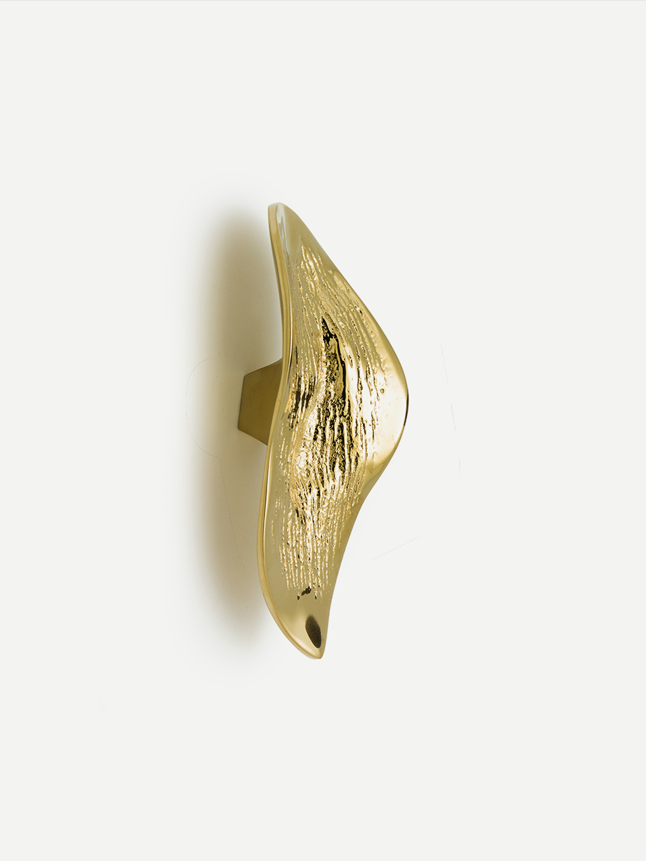 Textured cabinet and drawer pull in a Gold PVD finish, shaped like a leaf and inspired by natural lava flows. This luxuriously handcrafted piece adds an artistic and serene touch to your home interiors.