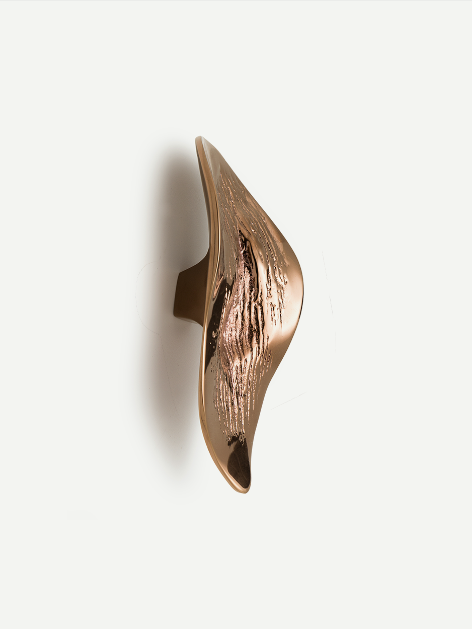 Textured cabinet and drawer pull in a Rose Gold PVD finish, designed to resemble a leaf and inspired by the natural shapes formed by lava. This luxurious, handcrafted pull brings elegance and tranquility to your home decor.